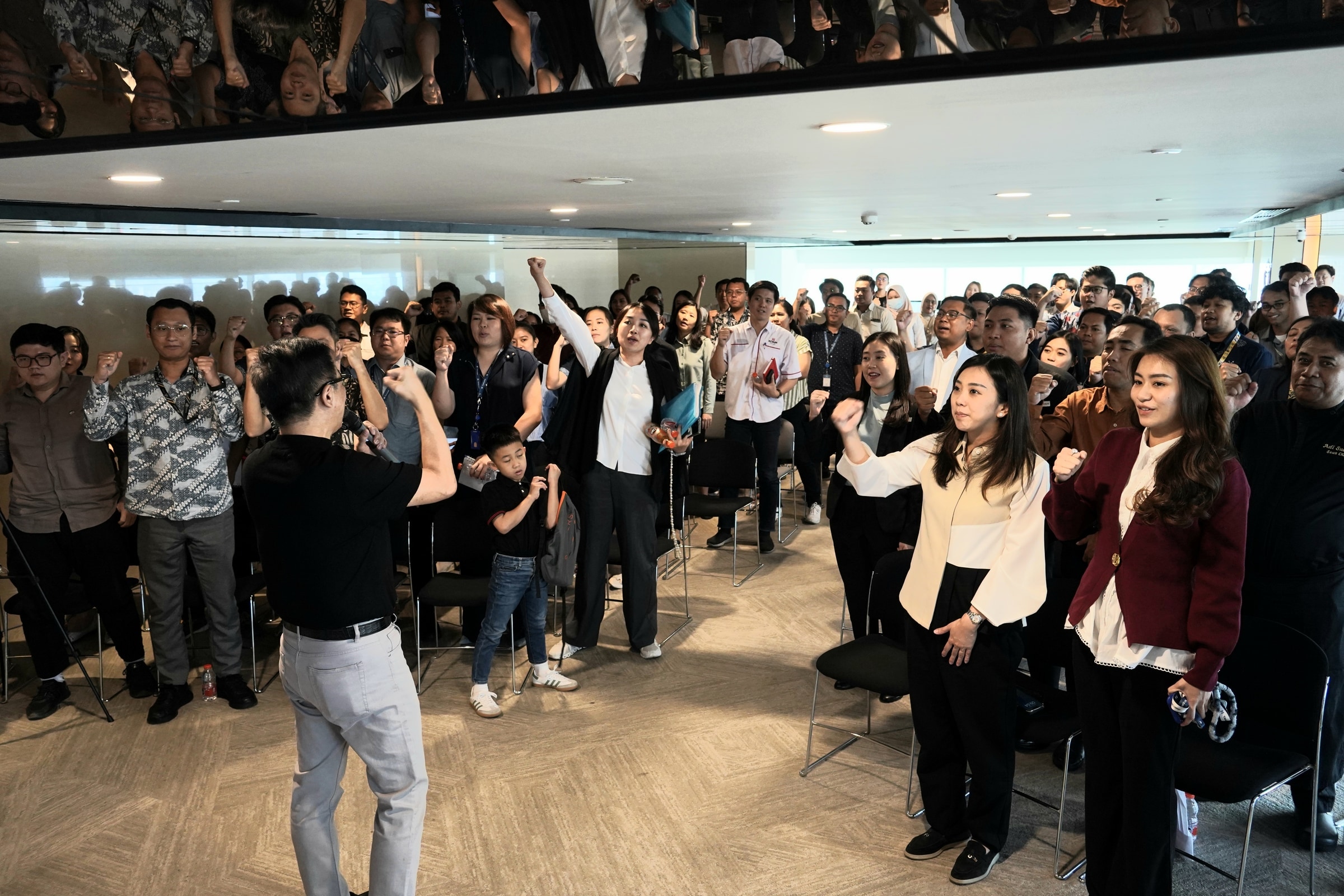Large standing group participating in a professional audience activity.