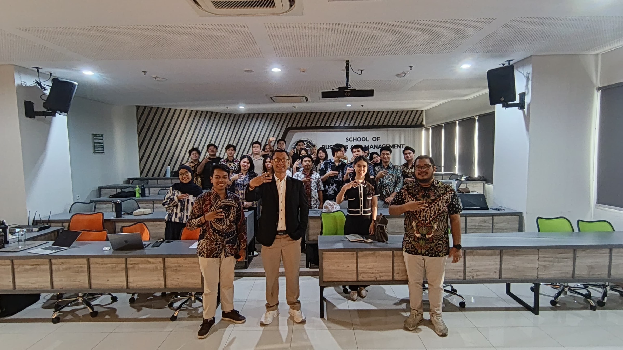 Olisiang in group workshop documentation with attendees at Universitas Ciputra.